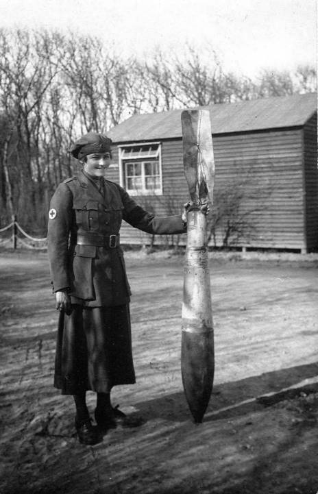 A First Aid Nursing Yeomanry driver with an unexploded German aerial bomb at a British hospital in Calais, 1918.